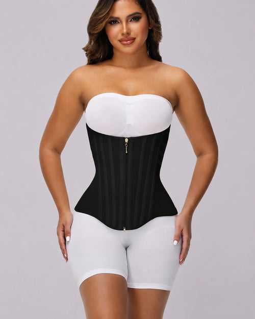 Full-body view of a model wearing a black waist cinching garment over white clothing, featuring a strapless style, front zipper closure, firm compression panels, and a defined hourglass shaping effect.