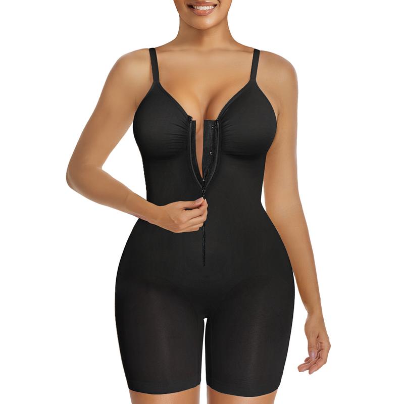 Front-facing product photo of a model wearing a sleek black compression garment with adjustable shoulder straps, a deep front neckline, zip fastening, fitted waist, and thigh-length legs.