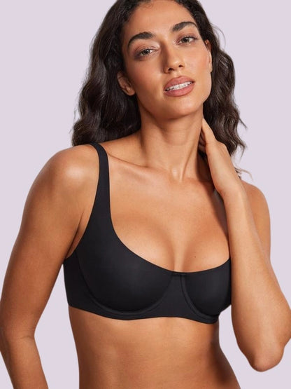 Woman modeling a black smooth-cup bra with broad fixed shoulder straps, a rounded neckline, and a supportive underbust band.