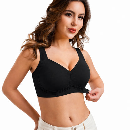 Front view of a woman wearing a black wireless bra with wide shoulder straps, smooth supportive cups, and a gathered center detail against a clean white background.